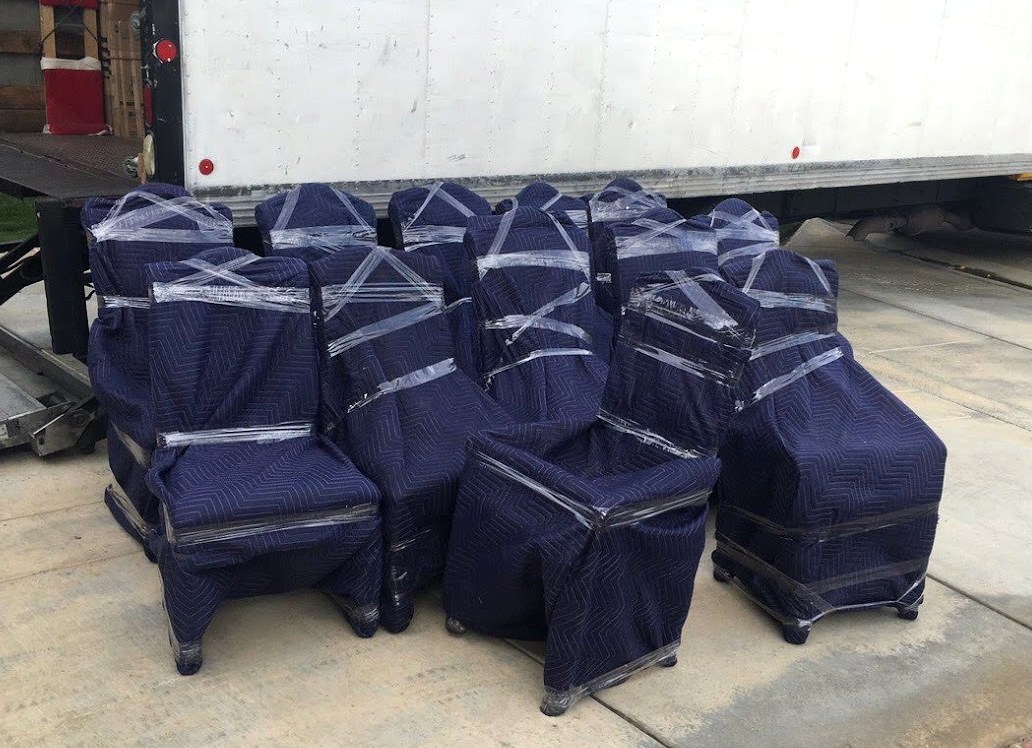 Wrapped patio furniture staged near a moving truck